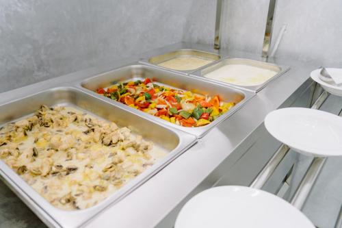 a table with three trays of food on it at PGA Hotel Free Shuttle to Airport in Tashkent