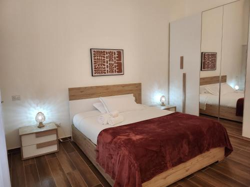 um quarto com uma cama grande e um espelho em Palazzo Manzoni Apartments em Bari