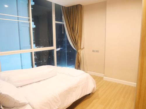Cama blanca en habitación con ventana en Rent-Saleคอนโดสุขุมวิท 2ห้องนอน 2ห้องน้ำ ใกล้ BTS อุดมสุข, en Ban Khlong Samrong