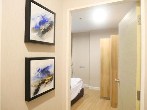 una camera da letto con due quadri incorniciati sul muro di Rent-Saleคอนโดสุขุมวิท 2ห้องนอน 2ห้องน้ำ ใกล้ BTS อุดมสุข a Ban Khlong Samrong