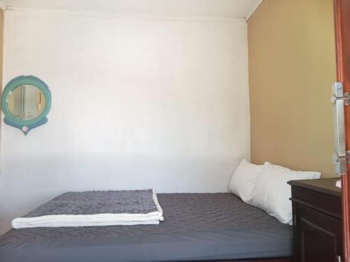 a bed in a small room with a mirror at Ya Bunayya Villa in Sembalun Lawang