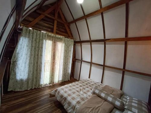1 dormitorio con 1 cama en una habitación con ventana en yadi Villa, en Sembalun Lawang