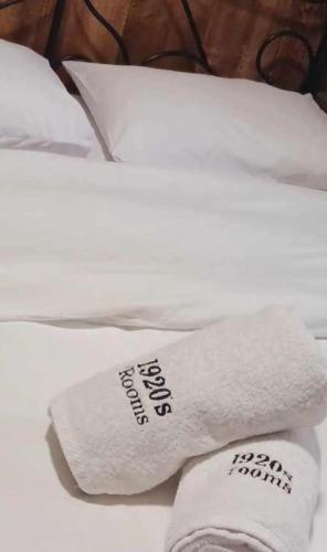a stack of white towels sitting on a bed at 1920s Rooms in Kalamata