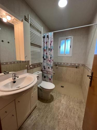 a bathroom with a sink and a toilet and a window at CA LA LIDIA in Porqueres