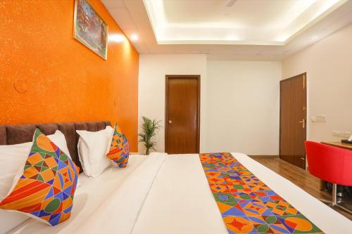 Habitación de hotel con cama y silla roja en FabHotel Spark Inn I, en Gurgaon