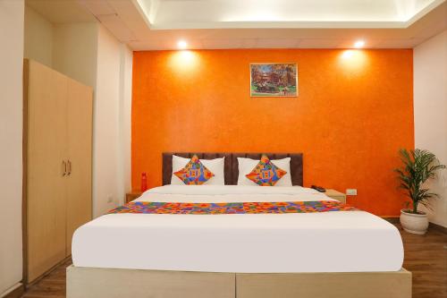 グルガオンにあるFabHotel Spark Inn Iのベッドルーム1室(オレンジ色の壁の大型ベッド1台付)