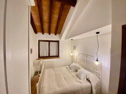 een slaapkamer met een wit bed en een houten plafond bij Villa tartufo in Toscella