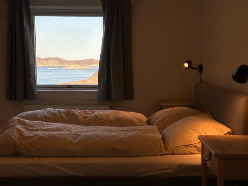 a bed in a room with a window at Illu Rental - Grand seaview vacation house in Ilulissat