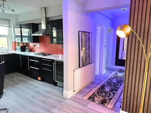 バーミンガムにある*Luxury 9ine Lush Jacuzzi Apartment & Balcony*の紫の壁と敷物が敷かれたキッチン
