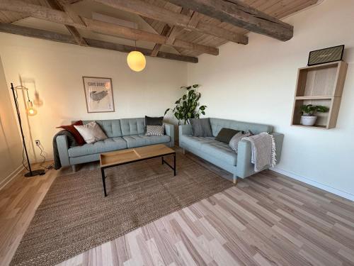 a living room with two couches and a coffee table at Illu Rental - Grand seaview vacation house in Ilulissat