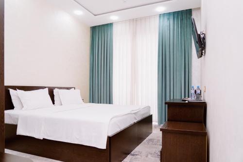 um quarto com uma cama e uma cortina verde em PGA Hotel Free Shuttle to Airport em Tashkent