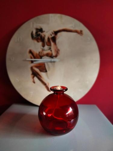 a red vase sitting on a table in front of a mirror at Addo's Secret Backdoor in Gqeberha
