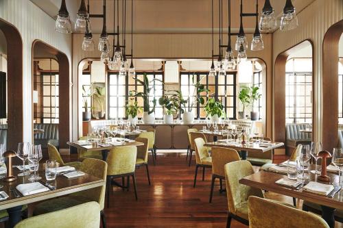 un restaurante con mesas, sillas y ventanas en Casiola Apartments in Four Seasons Miami, en Miami