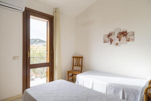 a white room with two beds and a window at Home Gioia Santa Maria in Baunei
