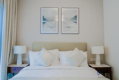 a bedroom with a bed with three pictures on the wall at Capital Stay- Private Two Bed Apartment - The Address Beach Resort Residences Fujairah in Fujairah
