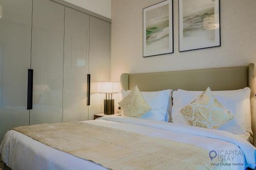a bedroom with a large bed with white sheets and pillows at Capital Stay- Private Two Bed Apartment - The Address Beach Resort Residences Fujairah in Fujairah