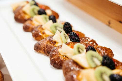 a white plate topped with pastries with fruit on top at Hotel Cristallo in Riccione