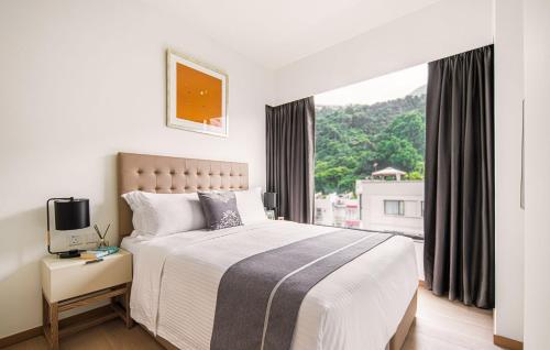 een slaapkamer met een groot bed en een raam bij Eaton Residences, Blue Pool Road in Hong Kong