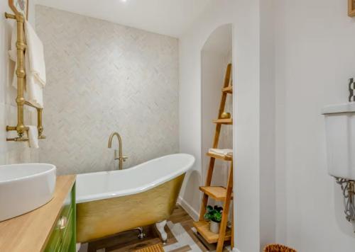 a bathroom with a tub and a sink at Wye Knot - Boutique 2 Bedroom Town House in Wilton