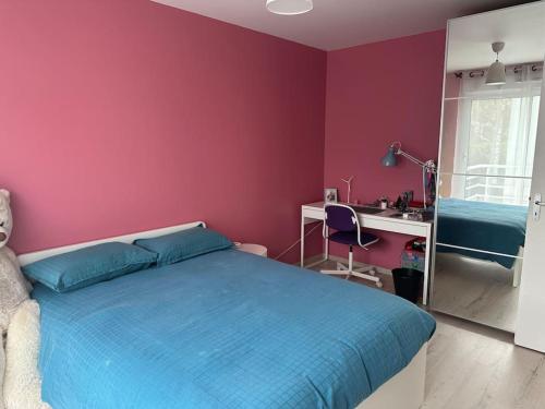 Schlafzimmer mit einem blauen Bett und einem Schreibtisch in der Unterkunft Maison moderne à 25 minutes du centre Paris et JO 2024 in Eaubonne