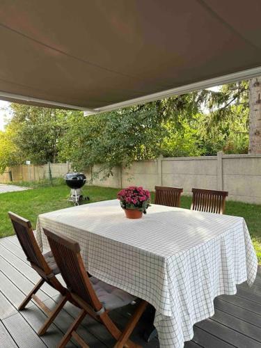 une table blanche avec des chaises et un vase de fleurs dans l'établissement Maison moderne à 25 minutes du centre Paris et JO 2024, à Eaubonne