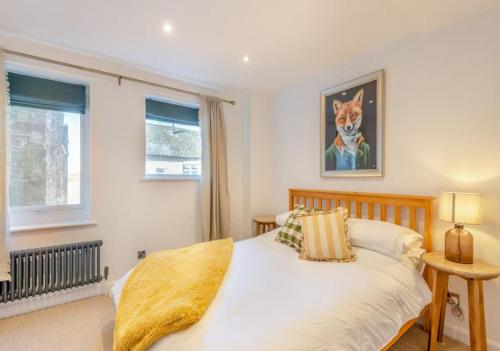 a bedroom with a white bed with a dog picture on the wall at Wye Knot - Boutique 2 Bedroom Town House in Wilton