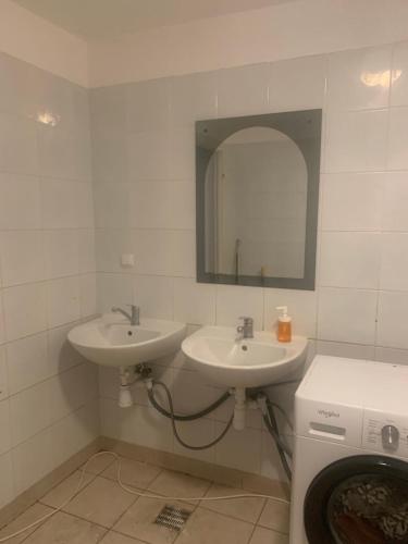 a bathroom with two sinks and a mirror and a washing machine at Central and affordable room in basement in Krakow