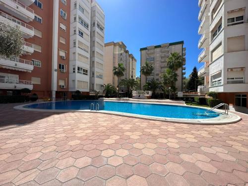 a swimming pool in the middle of some buildings at 400m playa con WiFi AC y piscina in Puerto de Gandía