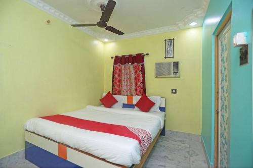 a bedroom with a bed with a ceiling fan at Hotel continental in kolkata