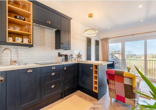 a kitchen with black cabinets and a counter top at Wye Knot - Boutique 2 Bedroom Town House in Wilton