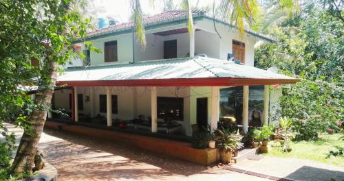 a house with a red roof at Geeth Lanka River Resort in Matale