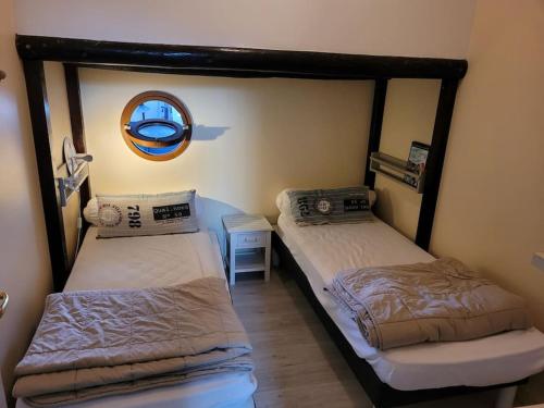 two twin beds in a room with a mirror at La goélette - Les Gîtes de la Côte d'Amour in Le Croisic