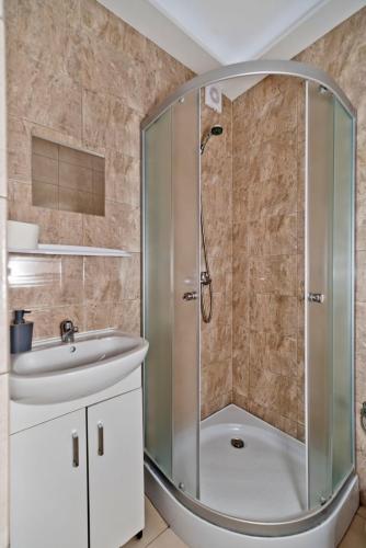 a bathroom with a shower and a sink at Resort EDEN - domki, pokoje, apartamenty, sauna, jacuzzi in Jastrzębia Góra
