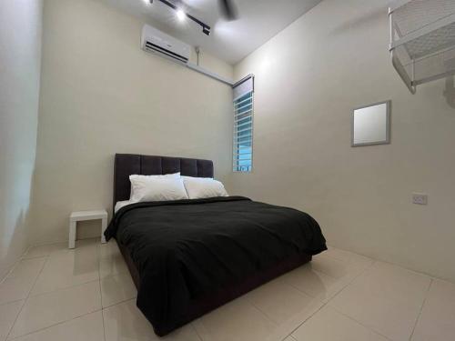 Double Seven Eight Homestay SemiD at Bandar Baru Setia Awan Perdana في سيتياوان: غرفة نوم بسرير أسود في غرفة بيضاء