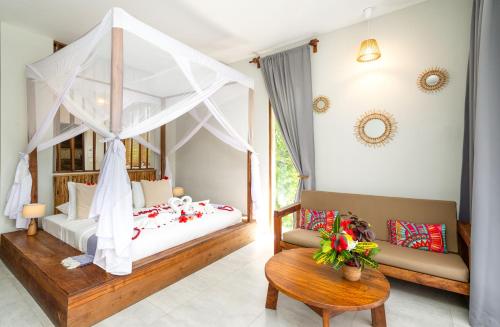 1 dormitorio con cama con dosel y sofá en Zanzibella Hotel & SPA en Kiwengwa