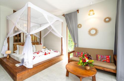 een slaapkamer met een hemelbed en een bank bij Zanzibella Hotel & SPA in Kiwengwa
