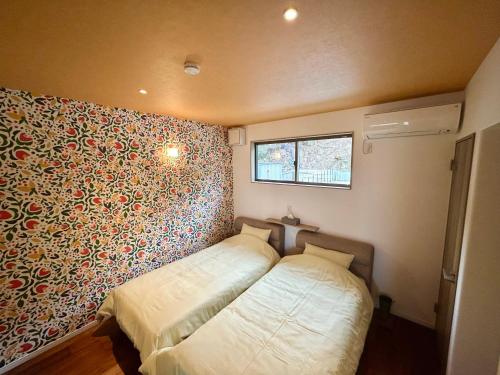 a bedroom with a bed and a floral wall at East Villa Shimanami Mukaishima seafront in Onomichi