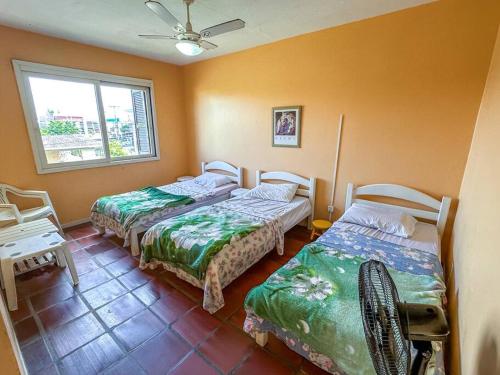 1 dormitorio con 2 camas y ventana en Apartamento Amplo em Capão da Canoa, en Capão da Canoa