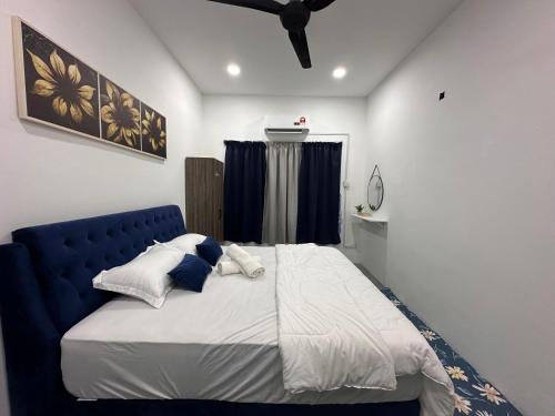 Bett mit blauem Kopfteil in einem Schlafzimmer in der Unterkunft One Mama’s Guest House in Kuala Selangor