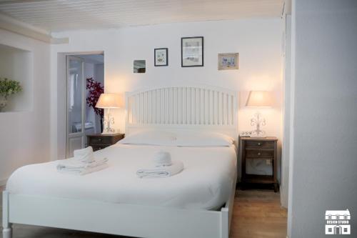 a white bedroom with a white bed and two night stands at MINI MAGIC by Design Studio in Varenna