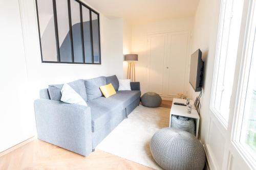 un salon avec un canapé bleu et une télévision dans l'établissement Le Cozy-Tours - Charmant appart en centre-ville, à Tours