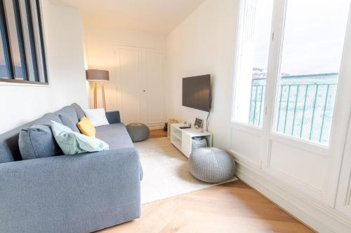 un salon avec un canapé bleu et une télévision dans l'établissement Le Cozy-Tours - Charmant appart en centre-ville, à Tours