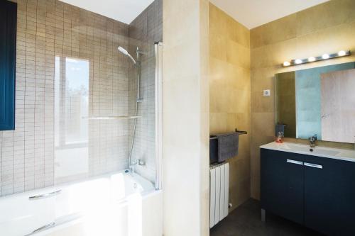 een badkamer met een bad, een wastafel en een douche bij Can Camarasa in Cervelló
