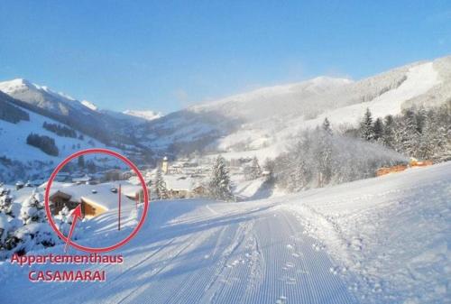 a picture of a snow covered slope with a house at Appartementhaus Casamarai in Saalbach Hinterglemm