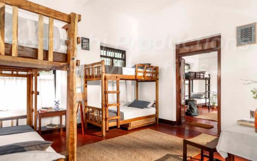 a room with three bunk beds and a mirror at Dutch Square Hostel in Alleppey