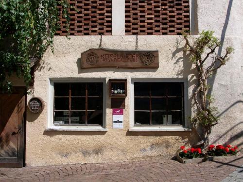 ein Gebäude mit zwei Fenstern und einem Schild darauf in der Unterkunft Weingut Köfelgut - Turris Vini in Kastelbell
