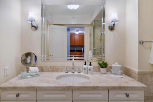 baño con lavabo y espejo grande en Casiola Apartments in Four Seasons Miami, en Miami