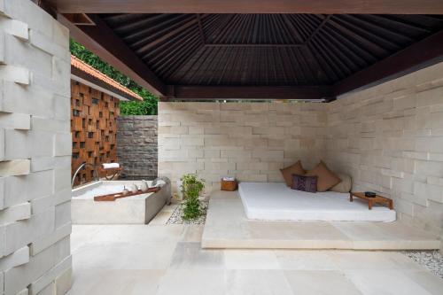a patio with a bed and a bath tub at Grand Hyatt Bali in Nusa Dua