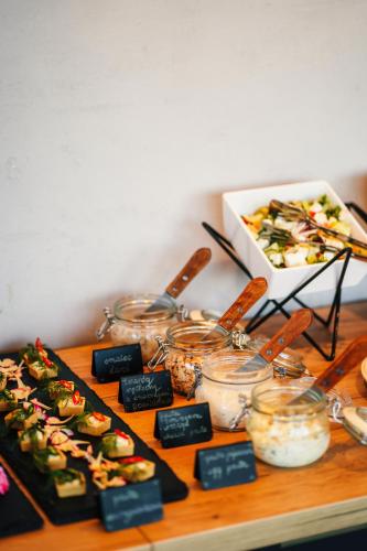 a table with a bunch of food in jars on it at Green Hotel in Inowrocław