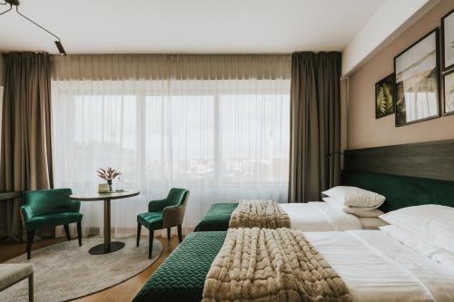 um quarto de hotel com uma cama e uma mesa com cadeiras em Green Hotel em Inowrocław